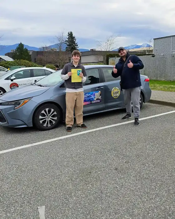 Jason Hildebrandt review photo showing road test success beside the Right of Way driving school car