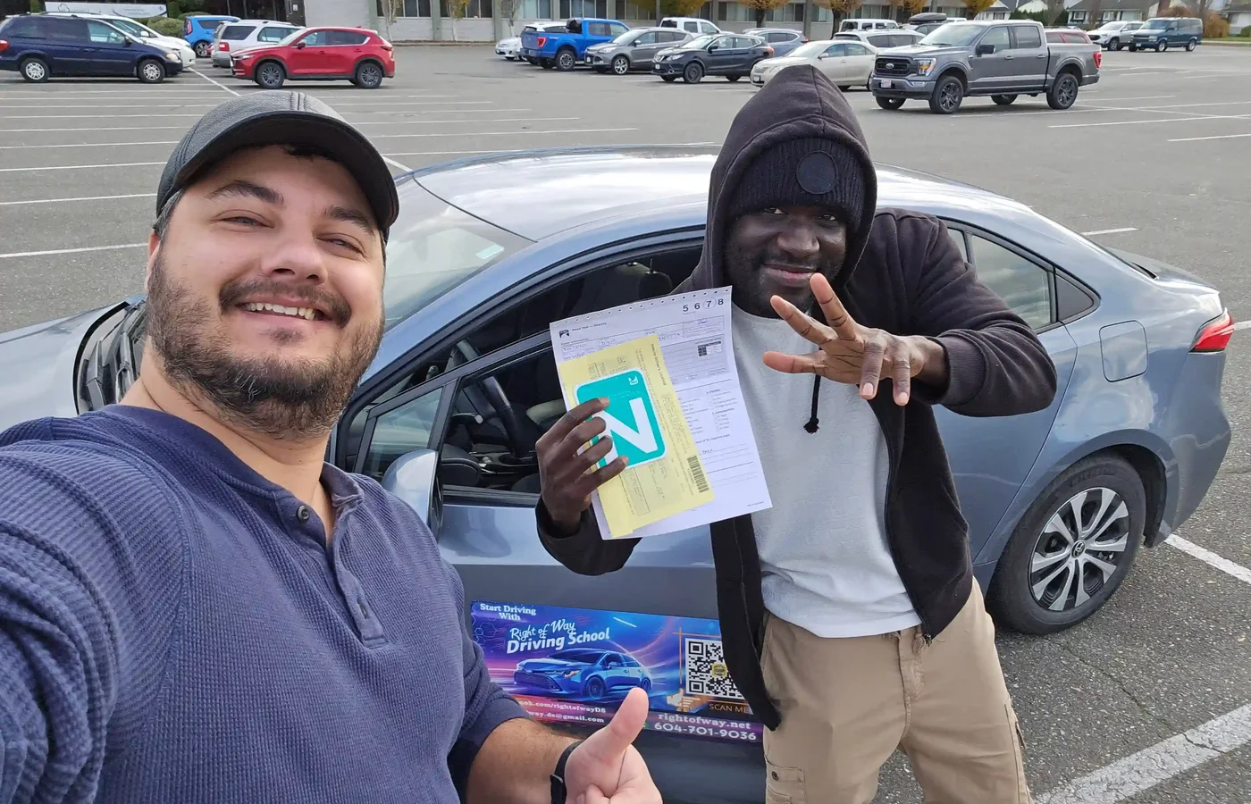Two students celebrating a passed road test in the Chilliwack ICBC parking lot